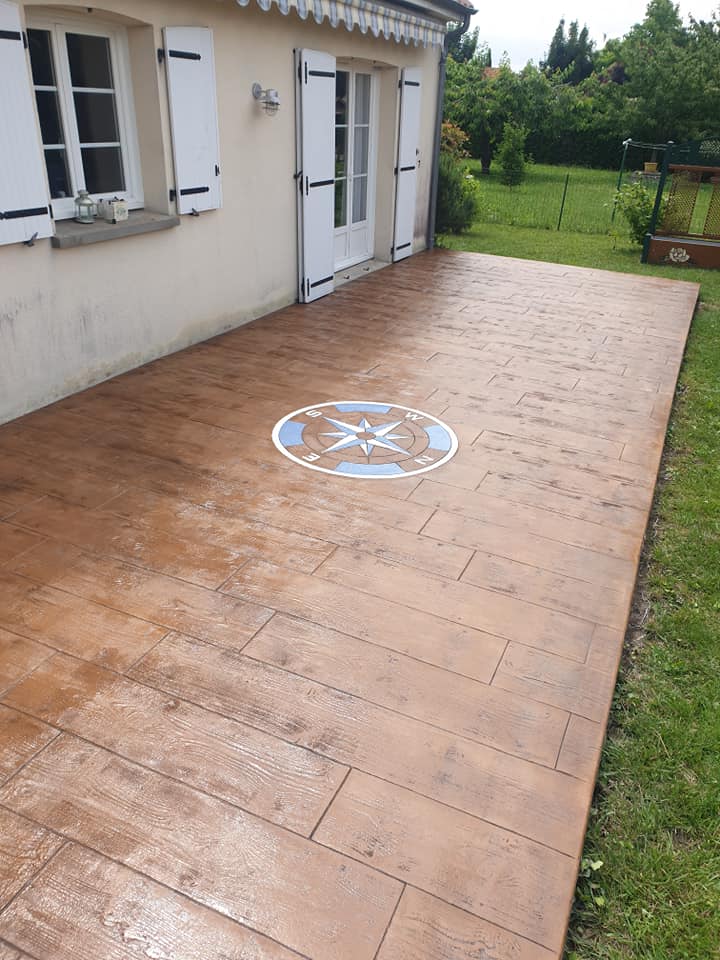 Terrasse en béton imprimé imitation bois avec une rose des vents au centre