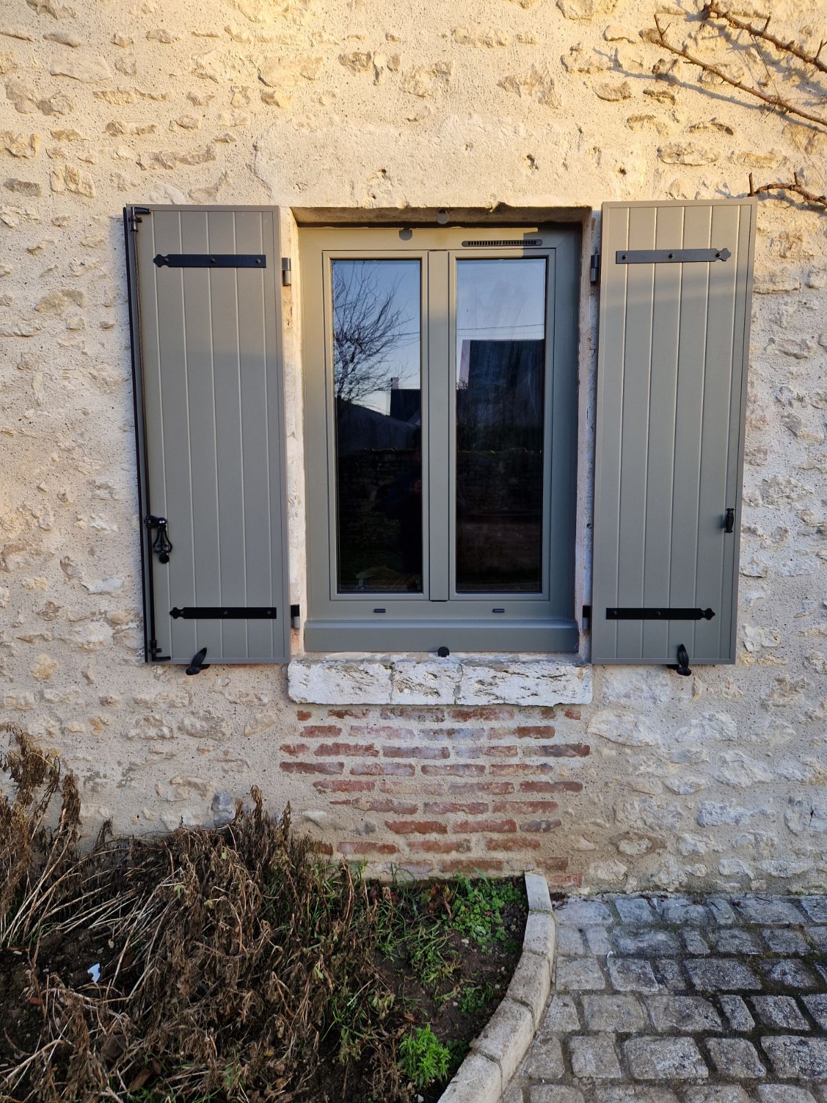 Pose de fenêtre avec volet battant de couleur gris