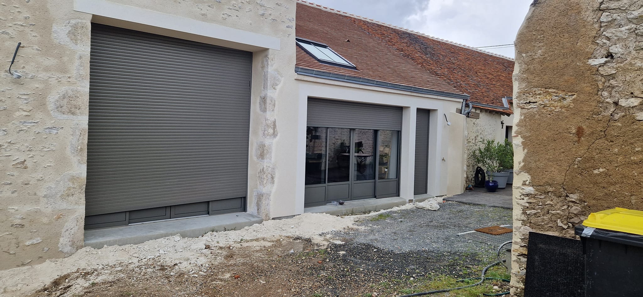 Rénovation et création d'une extension d'une maison avec menuiseries en aluminium. Travaux de maçonnerie sur la partie mur en pierre