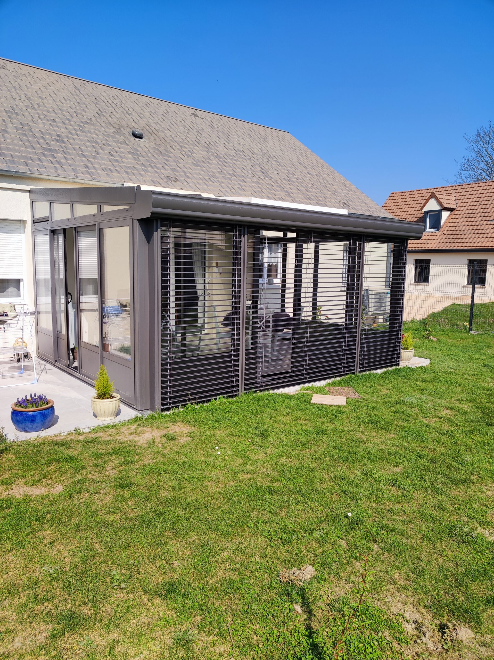 Véranda en aluminium avec store ajouré